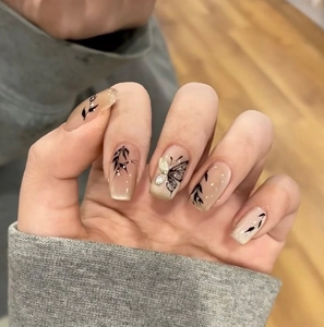 Faux ongles nude cat-eye avec motifs de feuilles et papillon 3D orné de strass brillants