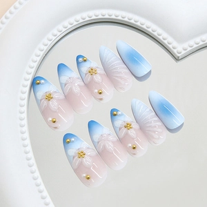 Unghie finte blu sfumate con fiori 3D bianchi e perle con forma a mandorla