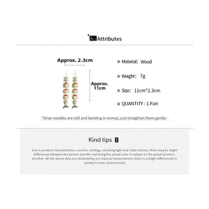 Detail view of ethnic long wood fish earrings showing dimensions 11cm by 2.3cm and 7g weight