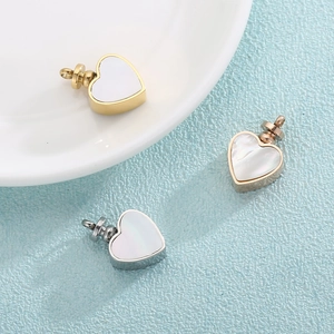 Polished heart pendant urn necklaces in gold, silver, and rose gold on a blue surface