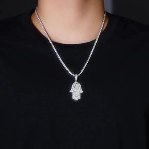 Macro shot of silver Hamsa hand pendant with micro-pave moissanite on tennis chain
