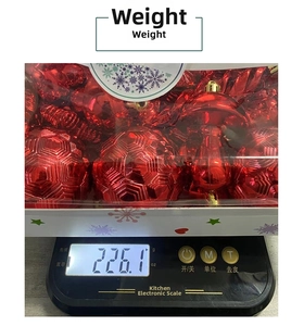 Detailed close-up of 28pcs red Christmas ball ornaments set showing net weight on a digital scale