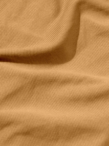 Close-up of camel brown pique knit fabric texture showing breathable structure and softness