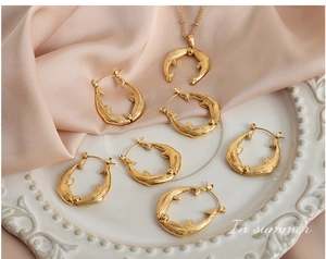 Detail view of a gold dolphin jewelry set with necklace and earrings on satin
