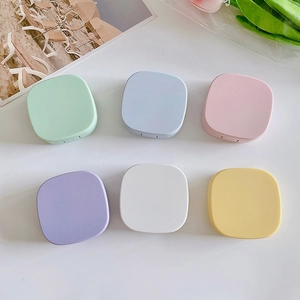 Close-up of portable square contact lens cases in six pastel colors with secure latch