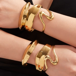 Brazaletes anchos dorados con curva en S y pulseras geométricas con textura