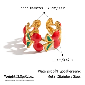 Detail of waterproof stainless steel cherry ring with red enamel and golden vine design