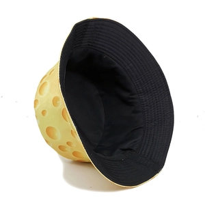 Reversible bucket hat featuring yellow swiss cheese print and solid black interior