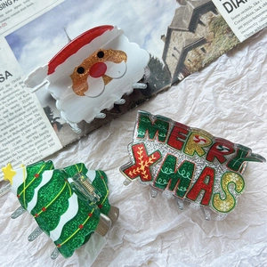 Detailaufnahme von weihnachtlichen Haarklammern mit Weihnachtsmann- und Baummotiven