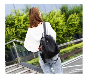 Outdoor model shot of black waterproof nylon anti-theft backpack for women