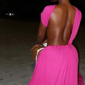 Detail of rose pink backless dress with ruched fabric and side tie design for women