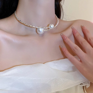 Detail of silver choker necklace with large white pearls shown on model neck