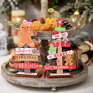 Close-up of wooden gingerbread man and Christmas tree ornaments on a festive tray