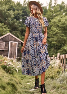 Détail de la robe longue bohème bleue à imprimé floral avec taille élastique dans un jardin
