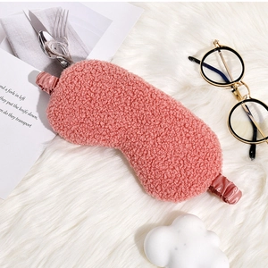 Detailed texture of a pink fuzzy teddy fleece sleep mask with elastic satin headband