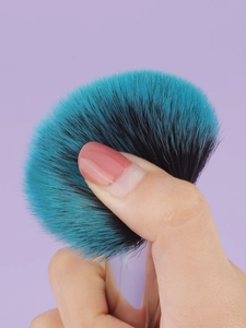 Macro shot of soft cyan synthetic bristles on makeup brush showing flexibility and bounce