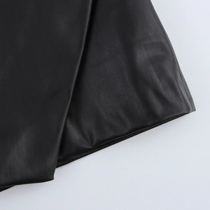 Close-up of black PU leather fabric showing textured grain and glossy finish of the A-line skirt