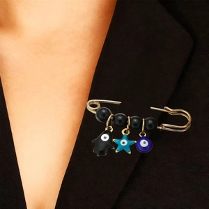 Détail d'une broche Hamsa et œil bleu sur le revers d'un blazer noir élégant