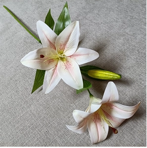 Close-up of artificial white lilies with realistic pink centers and green buds