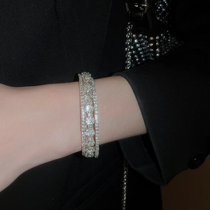 Close-up of sparkling multi-layer rhinestone flower bracelet on a black sleeve