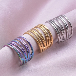 Vue détaillée de bagues multicouches en or et argent sur un tissu en soie rose doux