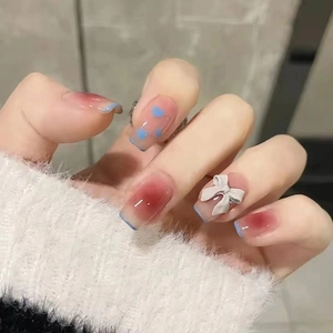 French ombre press-on nails with blue heart pattern and 3D white bow accessory
