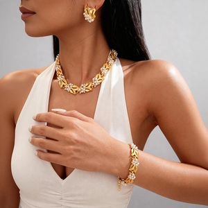 Close-up of elegant gold leaf necklace set with white pearls and sparkling rhinestones