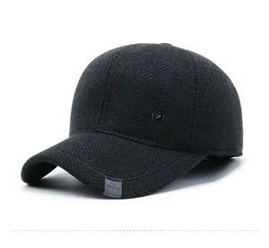 Detail of dark grey herringbone wool baseball cap with metallic logo and fashion label