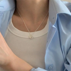 Close-up of S925 silver necklace with an abstract hollow heart pendant on a model