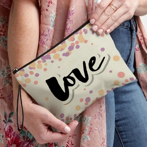 Chic canvas makeup bag with LOVE print and colorful dots, featuring a black wristlet strap