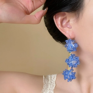Blue beaded flower earrings shown on model for a casual and elegant daily look