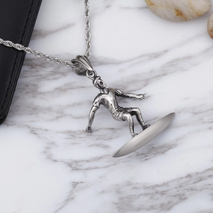 Silver punk style surfer pendant in stainless steel on marble background with accessories