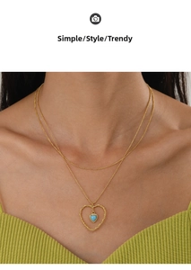 Gros plan d'un collier doré double épaisseur avec pendentif cœur sur mannequin en vert
