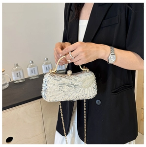 Detail of silver sequin evening clutch bag with metallic frame and gold chain strap