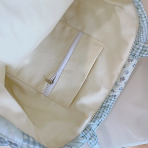 Detail view of cotton tote interior featuring zip pocket and floral quilted pattern