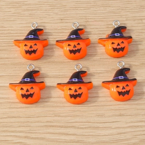 Close-up of 6 cartoon pumpkin charms with black wizard hats on a light wood surface
