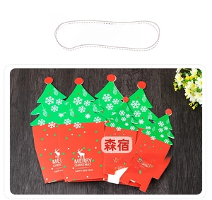 Christmas tree shaped apple gift box with red reindeer pattern on wooden background