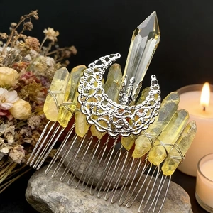 Macro shot of silver crescent moon hair comb with yellow raw crystal on natural stone