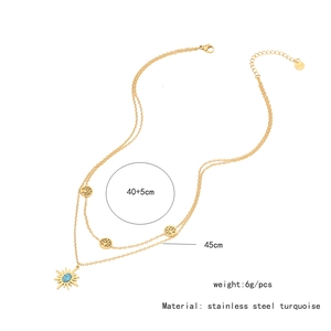 Detailed view of gold double-layer necklace with turquoise sun and tree of life pendants
