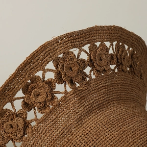 Handmade raffia straw hat with hollow floral patterns and foldable sun protection design