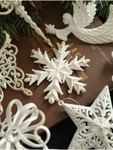 Macro shot of white and gold glitter angel wings and snowflake Christmas tree ornaments