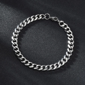 Sleek silver stainless steel Cuban link bracelet for couples on a matte black surface