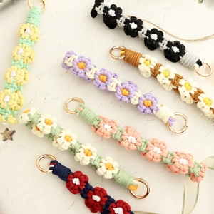 Macro view of handmade crochet floral wrist straps with gold metal lobster clasps