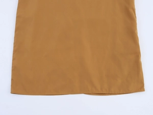 Close-up of the smooth hem stitching on a camel sleeveless coconut tree maxi dress