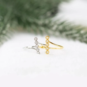 Detailed macro view of S925 silver and gold wave rings set with five vertical round zircons