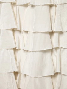 Detail of multi-layered ivory pleated fabric with elegant ruffled edges and satin texture