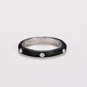 Close-up of black enamel band ring with sparkling cubic zirconia stones and silver interior