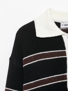 Close-up of contrast polo collar and striped knit texture on vintage black sweater