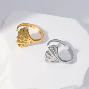 Macro detail of adjustable ginkgo leaf rings in gold and silver stainless steel finish