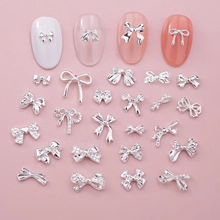 Silver alloy bow nail charms with metallic texture and rhinestones for Y2K nail art designs